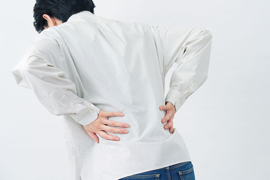 腰を抑える男性